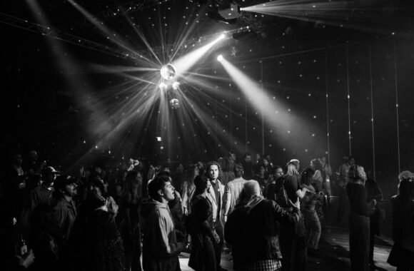 Pista de baile llena bajo luces de bola de discoteca