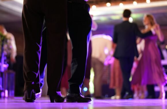 Invitados bailando en pista con iluminación morada